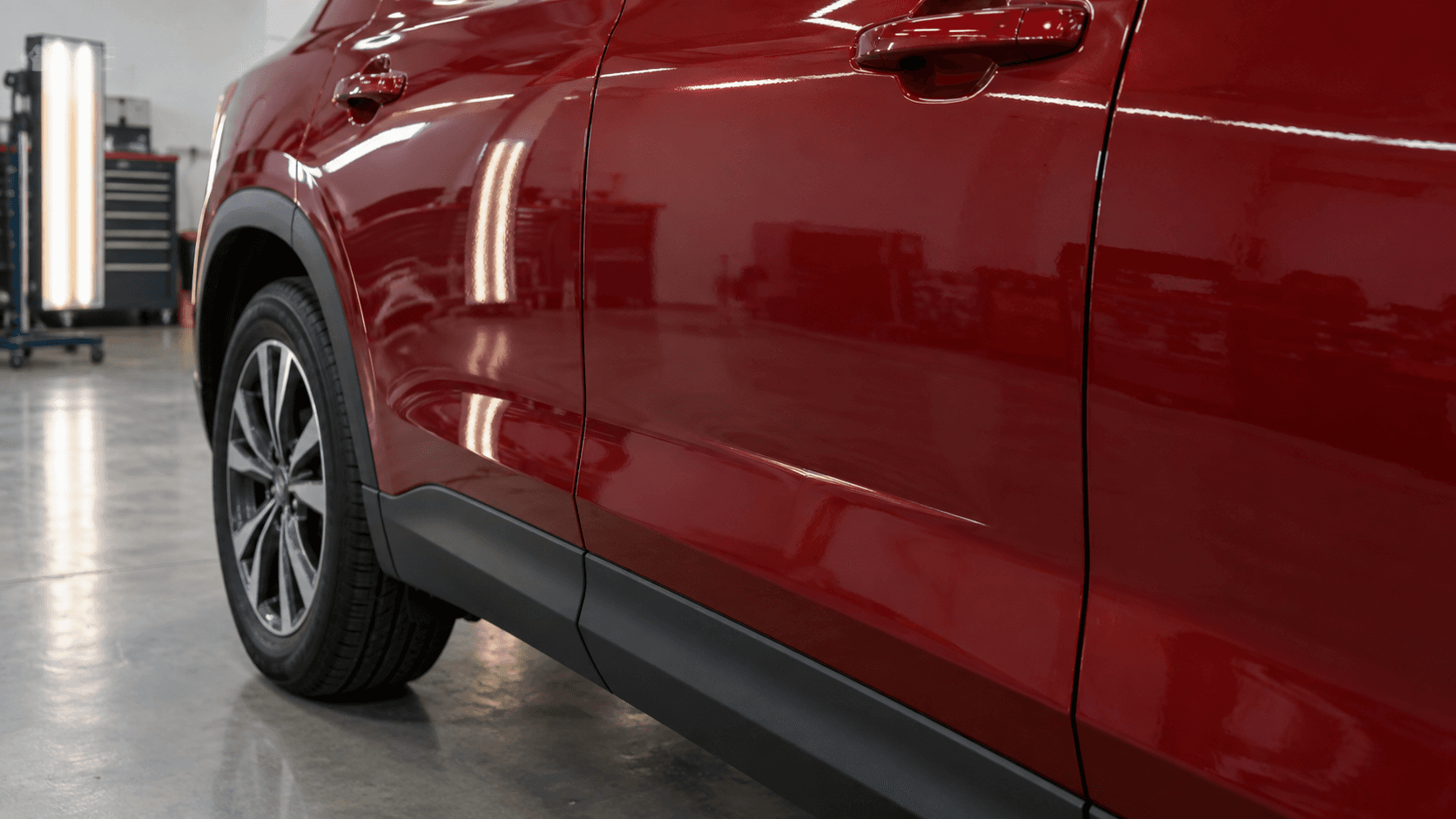 Narrow crease on a red SUV door before repair
